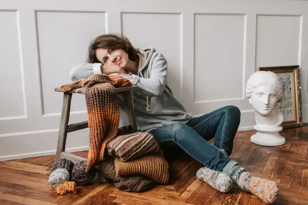 Matching knitted hat and gloves set resting on a wooden bench