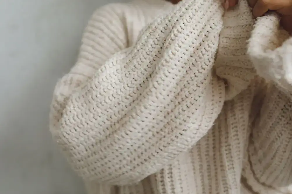 A person wearing a chunky knit cardigan