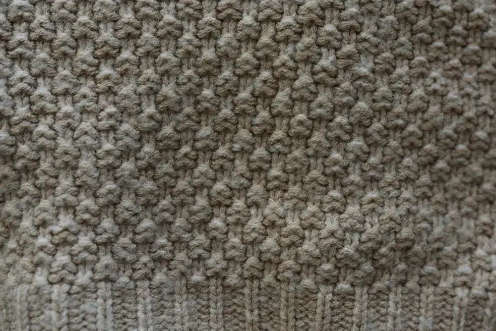 Close up of a heavy stitch wool sweater being examined